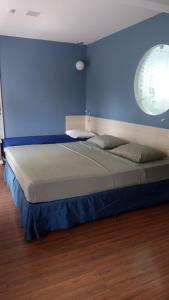 - un grand lit dans une chambre dotée d'un mur bleu dans l'établissement Flat no Mercure Navegantes, à Récife