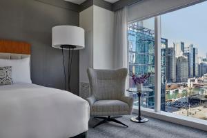 een slaapkamer met een bed, een stoel en een raam bij Loews Chicago Hotel in Chicago