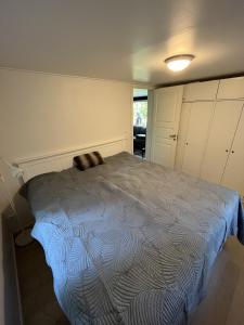 a bedroom with a bed with a blue comforter at Modern Forest Retreat in Örebro