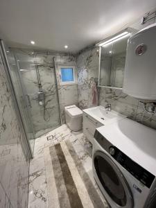 a bathroom with a shower and a washing machine at Modern Forest Retreat in Örebro +11 photos