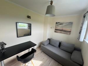 a living room with a couch and a table at Nemo - apartament, domek w Gaskach in Gąski