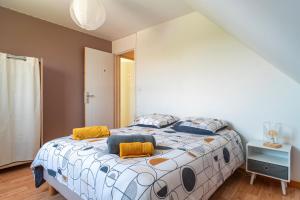 Un dormitorio con una cama grande con almohadas naranjas y azules. en Cocon vert proche mer, en Plouhinec