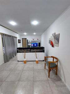 a living room with a tv and a couch and a chair at Complejo calle Cordoba Departamento 2 in General Roca +7 photos