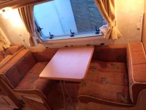- un salon avec une table et une fenêtre dans l'établissement Camping du Puy Rond, à Bressuire