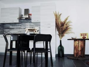 una cocina con mesa negra y sillas en Monolocale di 55mq in villa 8km da Pompei, en San Giuseppe Vesuviano