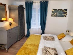 a bedroom with two beds and a window with blue curtains at Mirka & Franck AIRCON Apartment Chic 4" Stars Parking Free, Garage & Wine with Avantages Pack in Colmar +27 photos