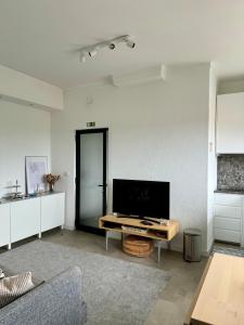 een woonkamer met een tv en een tafel bij WORK&STAY - Apartamento no centro de Coimbra in Coimbra