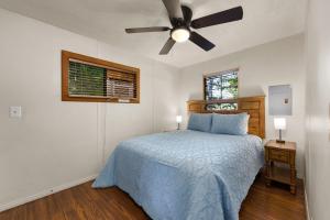 um quarto com uma cama e uma ventoinha de tecto em The Sequoia House em Kernville