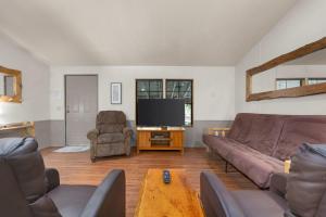 uma sala de estar com um sofá e uma televisão de ecrã plano em The Sequoia House em Kernville