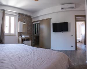 1 dormitorio con 1 cama y TV de pantalla plana en la pared en Host4ALL PALOMBINA en Falconara Marittima