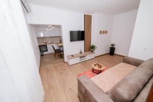 特雷比涅Apartman KOSTA 2的客厅里有一张沙发和一张桌子。