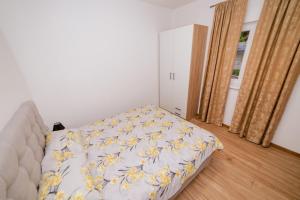 特雷比涅Apartman KOSTA 2的一间卧室配有一张黄色和白色毯子的床