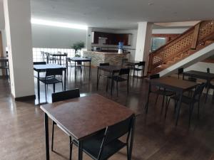 uma sala de jantar com mesas, cadeiras e escadas em HOTEL QUINTA ESTACIÓN em Caldera
