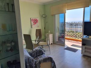 una sala da pranzo con tavolo in vetro e balcone di Tulipa View Apartament a Funchal