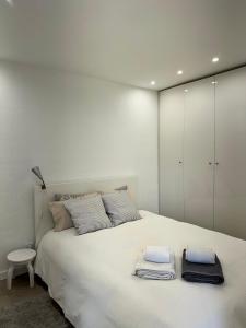 een slaapkamer met een groot wit bed en handdoeken bij WORK&STAY - Apartamento no centro de Coimbra in Coimbra