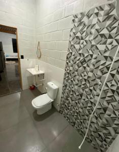 a bathroom with a toilet and a sink at Espaço Mattigor in Caçapava