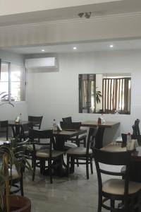 門多薩的住宿－西耶娜酒店，用餐室设有桌椅和窗户。