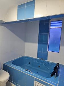 a blue tub in a bathroom with a toilet at HOTEL BIG BEN MALAGA SANTANDER in Málaga