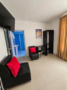 a living room with black furniture and red pillows at HOTEL BIG BEN MALAGA SANTANDER in Málaga