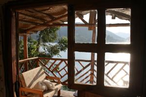 una finestra aperta di una camera con vista sull'acqua di Amasiko Homestay Lake Bunyonyi a Kabale