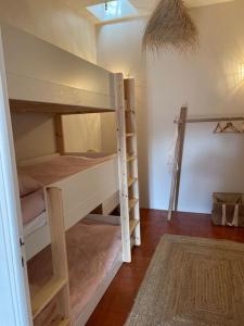 CateriにあるRavissante maison entre ile rousse et calviの二段ベッド2台とラグが備わる客室です。