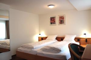 - une chambre avec deux lits, une table et une chaise dans l'établissement Hotel Freihof Swiss Lodge, à Unterägeri