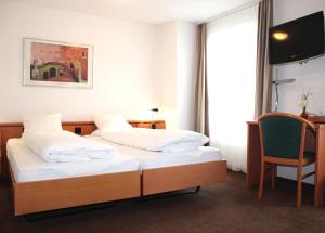 安特拉格里Hotel Freihof Swiss Lodge的有两张床和一把椅子的酒店房间