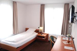 una camera d'albergo con letto, scrivania e finestra di Hotel Freihof Swiss Lodge a Unterägeri