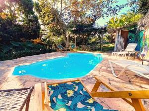 a pool with a table and chairs next to it at Recanto Arandu - Boutique Hotel & Retiros in Palmeiras