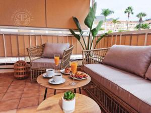 Un balcón con 2 sofás y una mesa con bebidas. en 2 Wings Tenerife - Apartment Chayofa en Chayofa
