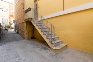 un escalier menant à un bâtiment jaune dans l'établissement Host4ALL PALOMBINA, à Falconara Marittima