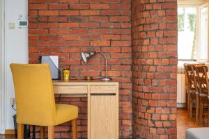 a desk with a yellow chair next to a brick wall at Bricks & Bikes in Zagreb +18 photos