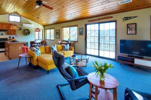 sala de estar con muebles de color amarillo y TV de pantalla plana. en The Atomic Squirrel Lodge Lake Gregory Getaway!, en Crestline