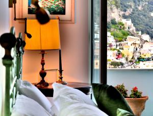 a bedroom with a bed with a lamp and a window at Villa Positano with sea view ! in Positano