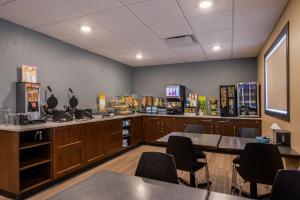 a waiting room with tables and chairs in a restaurant at Chateau All Suites Hotel in Kindersley
