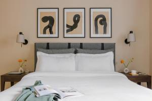 ロンドンにあるサコ フィッツロビアのベッドルーム1室(壁に3枚の写真が飾られたベッド1台付)