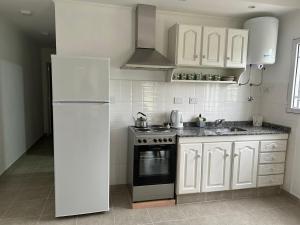 a kitchen with white cabinets and a white refrigerator at La Celestina in Ramallo