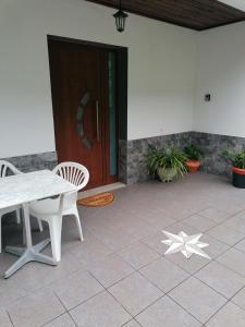 a patio with a table and chairs in front of a door at Mountain retreat in Boaventura