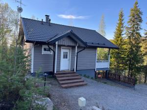 una pequeña casa con porche y escaleras en un patio en Villa IRIS 3, Himos, en Jämsä