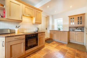 eine große Küche mit Holzschränken und -geräten in der Unterkunft Hillside Cottage in Ambleside + 14 Fotos