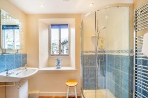 ein Badezimmer mit Waschbecken und Dusche in der Unterkunft Hillside Cottage in Ambleside