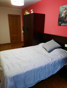 1 dormitorio con cama blanca y pared roja en Pamplona Room en Pamplona