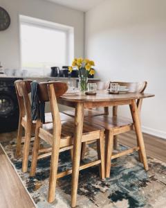 a wooden table and chairs with a vase of flowers at Ty Ray Penmaes in Rhayader +16 photos