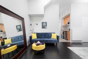salon z niebieską kanapą i żółtymi krzesłami w obiekcie Cozy Studio Next To Public Transport w mieście Toronto
