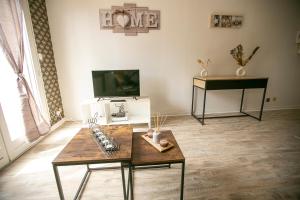 a living room with a table and a tv at La Téranga - WIFI - Coeur de ville - Gare in Les Mureaux