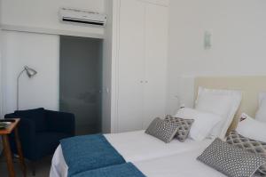 オビドスにあるEntre Vinhas & Marのベッドルーム1室(ベッド1台、青い椅子付)