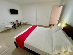 1 dormitorio con 1 cama grande con manta roja y blanca en San Laurent, en Cali