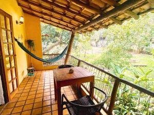 パウメイラスにあるRecanto Villa São Joãoのポーチ(ハンモック、テーブル、椅子付)