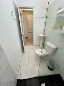 een badkamer met een toilet en een glazen douche bij San Laurent in Cali