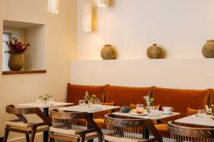 un restaurante con mesas y sillas y un sofá en Yelo Belle Epoque powered by Sonder en Cannes